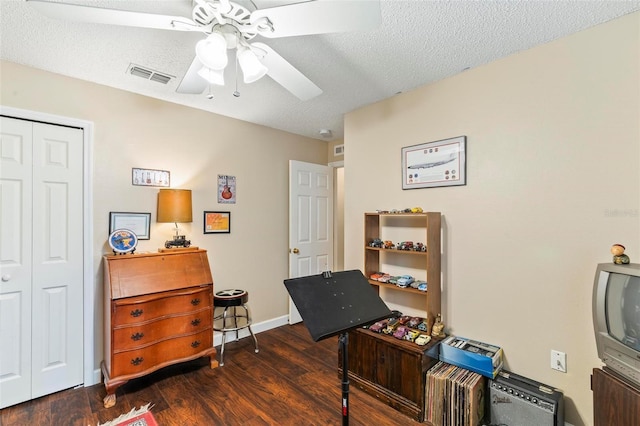 interior space with ceiling fan, dark hardwood / wood-style flooring, and a textured ceiling