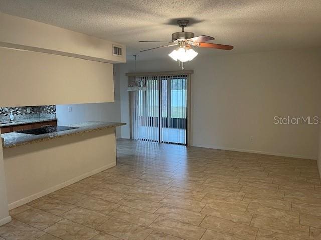 empty room featuring ceiling fan and a textured ceiling