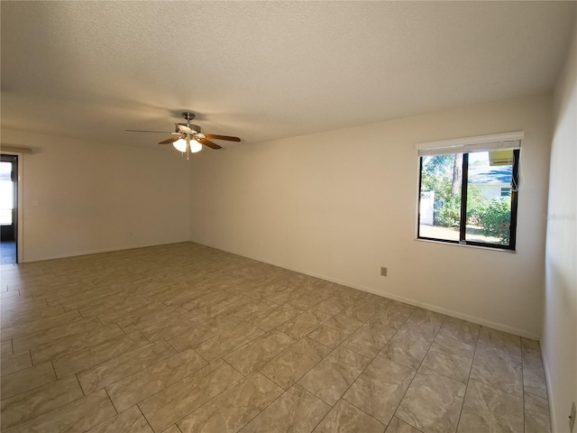 spare room with a textured ceiling and ceiling fan