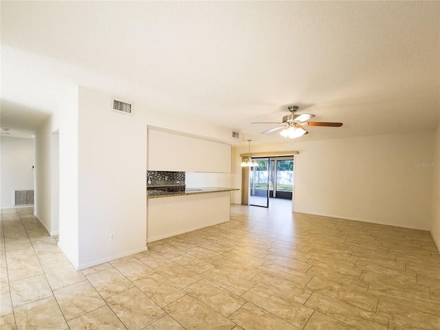 unfurnished living room featuring ceiling fan