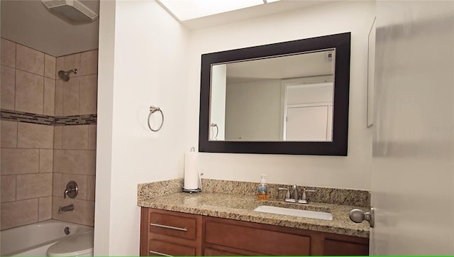 bathroom with tiled shower / bath and vanity