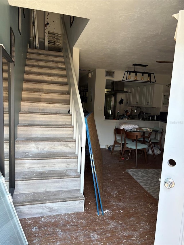 stairway with a textured ceiling