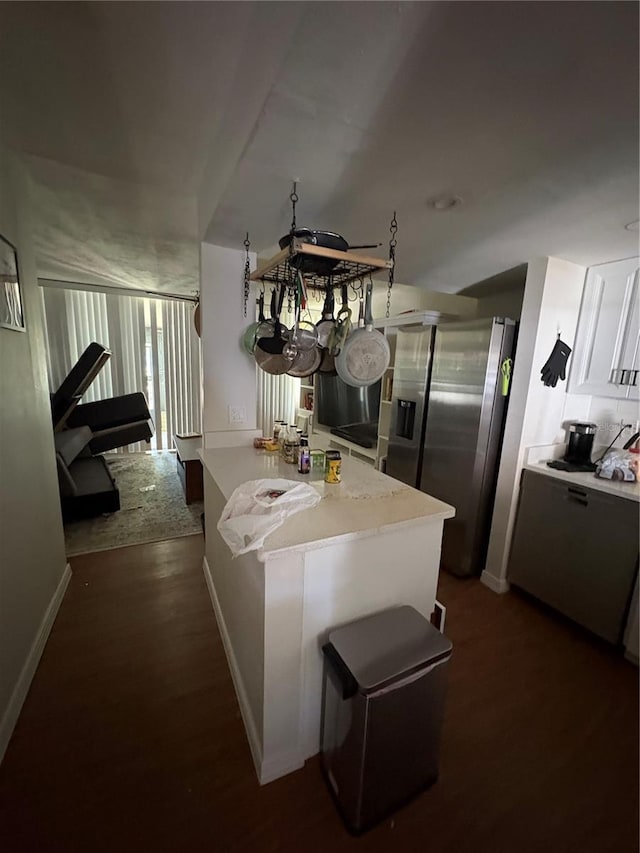 kitchen with stainless steel fridge with ice dispenser, white cabinetry, backsplash, dark hardwood / wood-style flooring, and kitchen peninsula