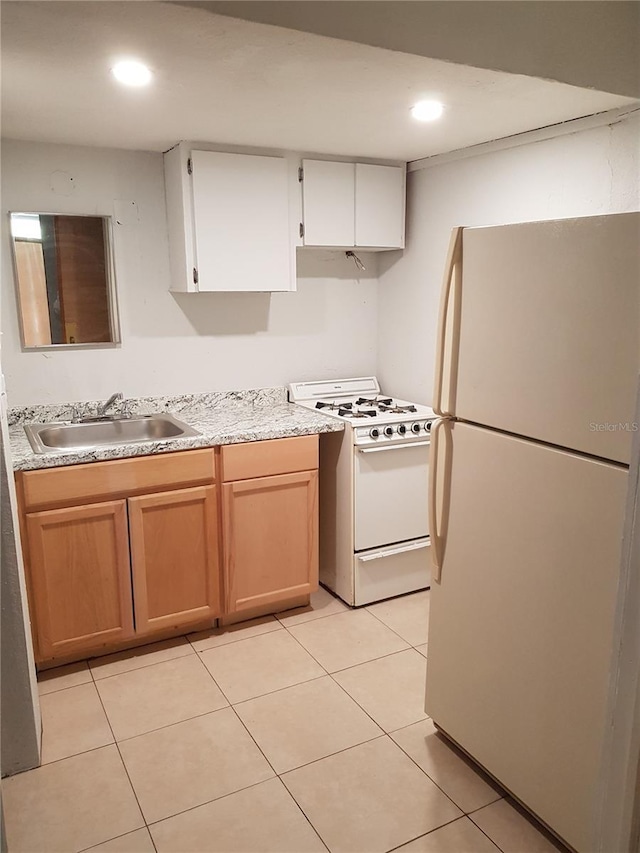 kitchen featuring sink, white appliances, white cabinets, and light tile patterned floors