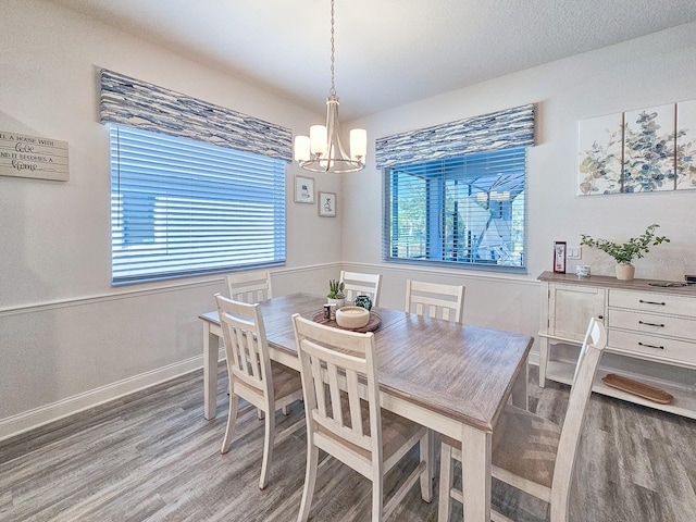 dining room with a chandelier, hardwood / wood-style floors, and a textured ceiling