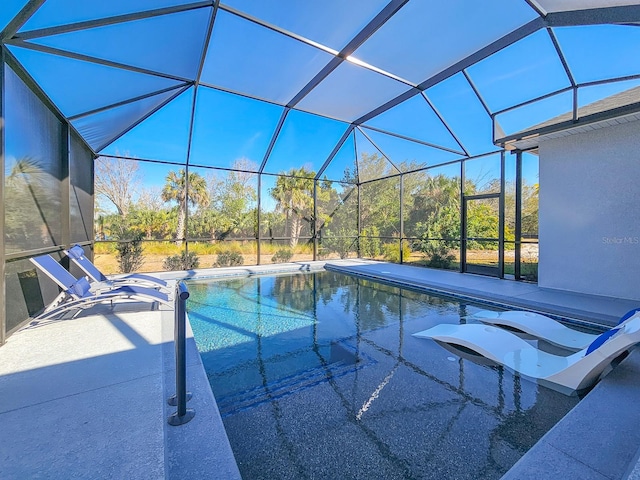 view of swimming pool featuring a patio and glass enclosure