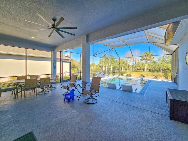 view of patio with ceiling fan and glass enclosure