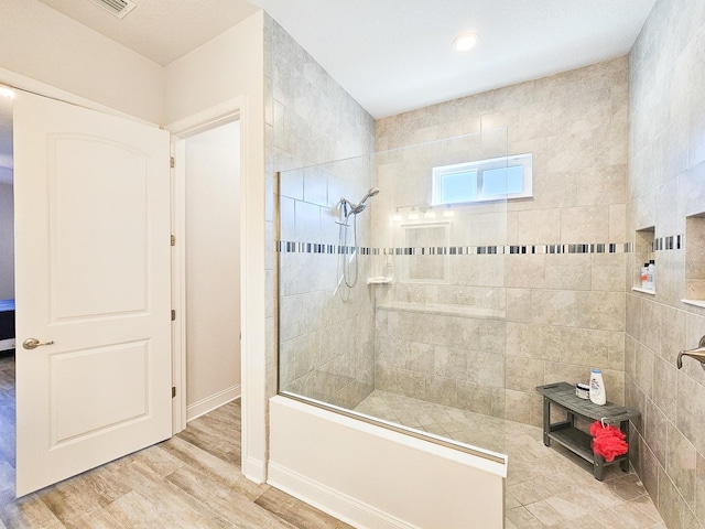 bathroom featuring tiled shower and hardwood / wood-style floors