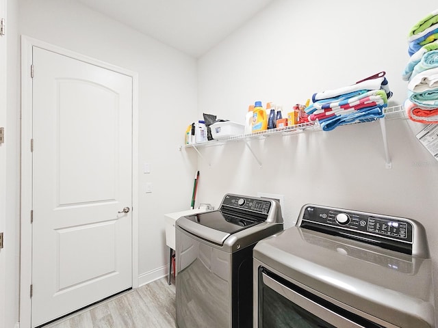 laundry room featuring sink, light hardwood / wood-style floors, and washer and dryer