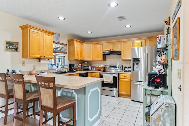 kitchen with a kitchen bar, sink, light tile patterned floors, appliances with stainless steel finishes, and kitchen peninsula