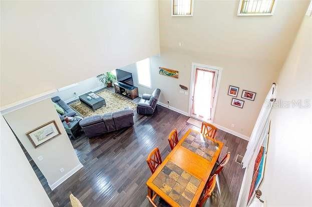 living room featuring a towering ceiling and dark hardwood / wood-style flooring