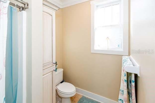 bathroom with crown molding and toilet