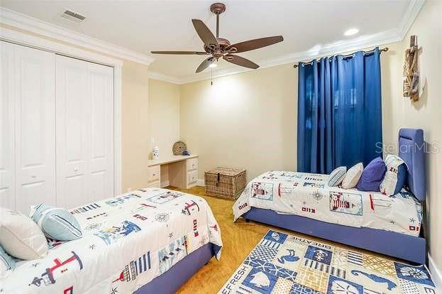 bedroom with hardwood / wood-style flooring, a closet, ceiling fan, and ornamental molding