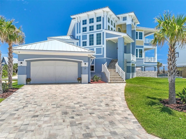 view of front of house with a garage, a balcony, and a front lawn