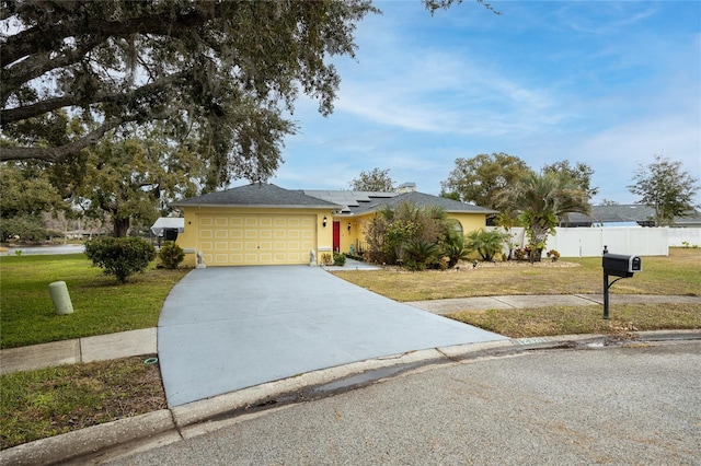 ranch-style house featuring a garage, a front lawn, and solar panels