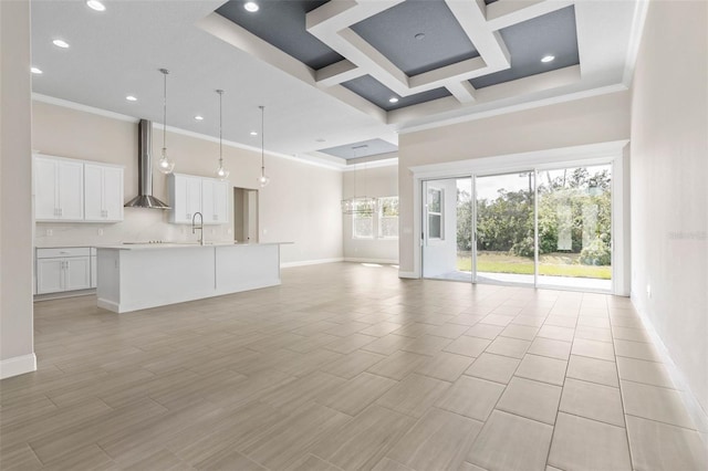 unfurnished living room with a high ceiling, baseboards, and a sink