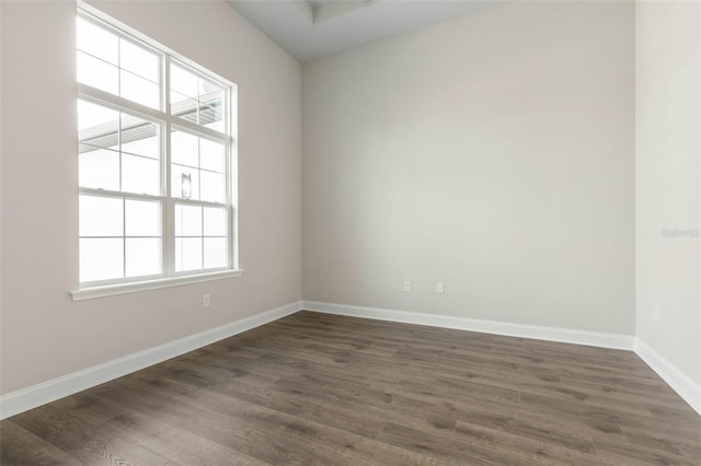 unfurnished room featuring dark wood-type flooring and baseboards