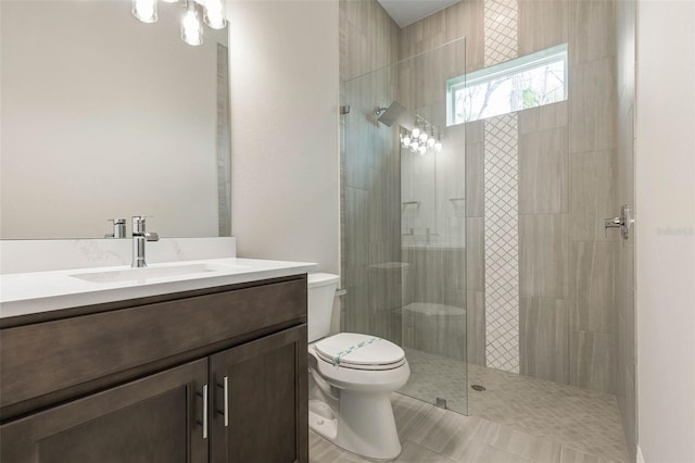 bathroom featuring a walk in shower, toilet, and vanity