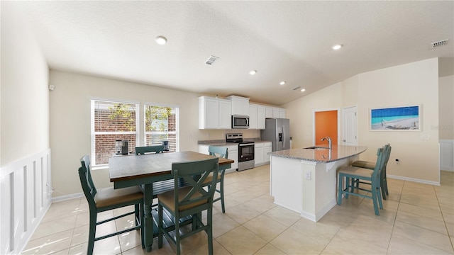 kitchen featuring sink, white cabinets, light stone countertops, a kitchen island with sink, and stainless steel appliances