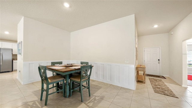 tiled dining area featuring a textured ceiling