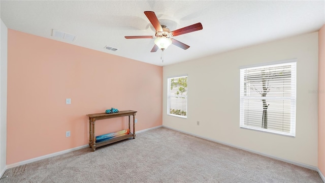 unfurnished room with ceiling fan, a healthy amount of sunlight, and light carpet