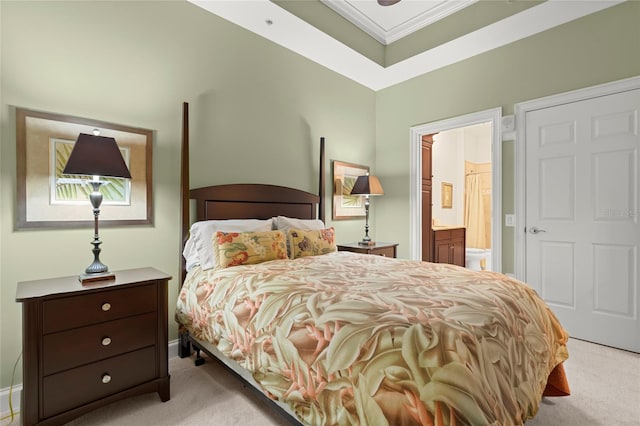 bedroom featuring ensuite bathroom, ornamental molding, and carpet flooring