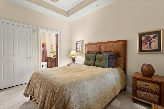 carpeted bedroom featuring ornamental molding and ensuite bathroom