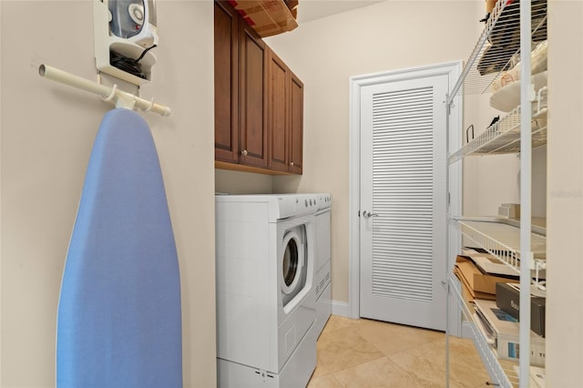 laundry area featuring light tile patterned floors, cabinet space, and washer and dryer