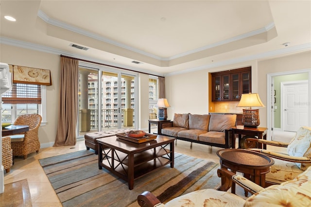 living room featuring visible vents, a raised ceiling, and crown molding