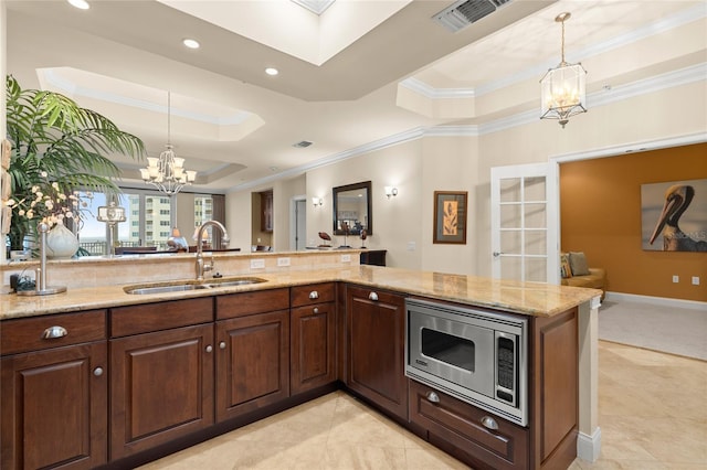 kitchen with visible vents, a raised ceiling, stainless steel microwave, a chandelier, and a sink