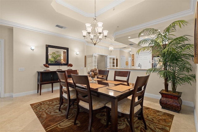 dining room featuring visible vents, a chandelier, a tray ceiling, and ornamental molding