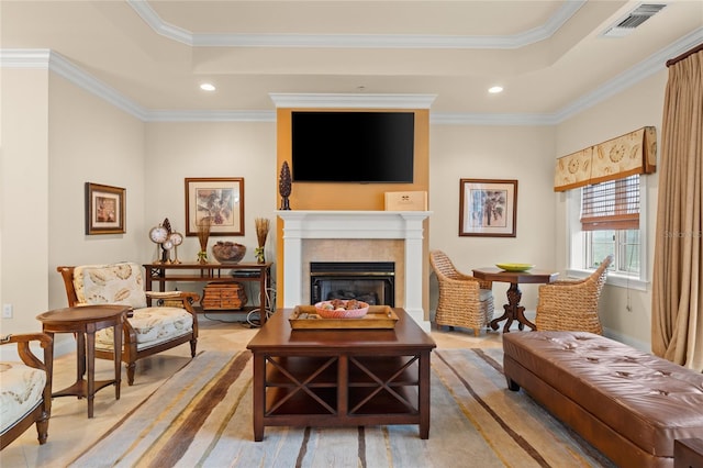 sitting room featuring a tray ceiling, a glass covered fireplace, visible vents, and crown molding