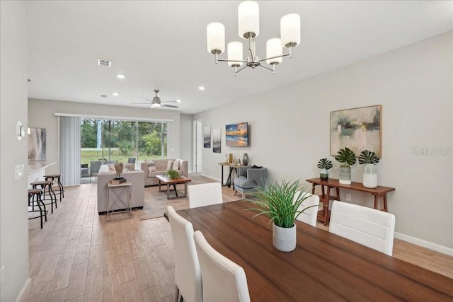 dining room with light wood-type flooring and ceiling fan with notable chandelier