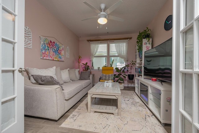 living room with ceiling fan and a textured ceiling