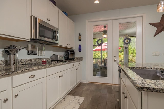 kitchen with french doors, white cabinetry, light stone counters, and dark wood-type flooring