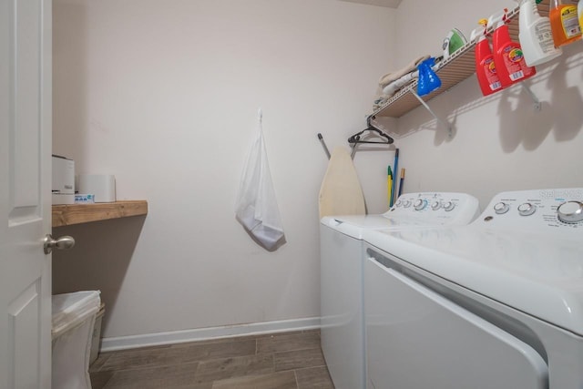 clothes washing area with dark wood-type flooring and washing machine and dryer