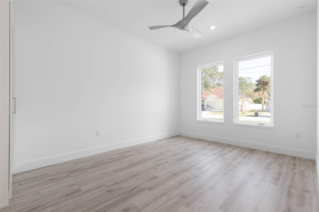 empty room with ceiling fan and light hardwood / wood-style flooring