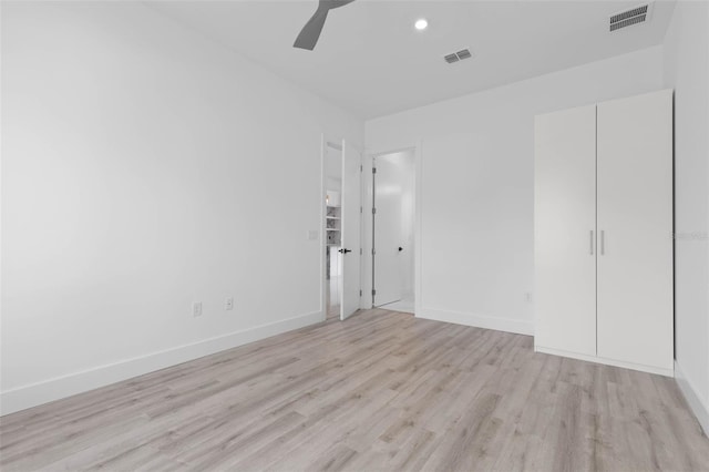 unfurnished bedroom with ceiling fan, light hardwood / wood-style floors, and a closet