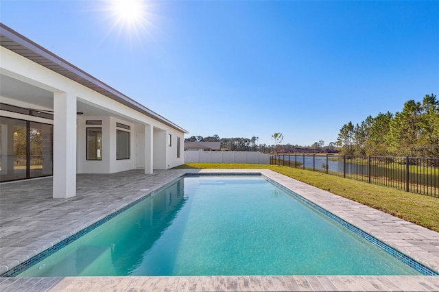 view of pool featuring a yard, a patio area, and a water view