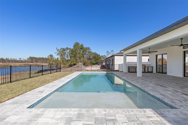 view of pool with a patio, ceiling fan, and a water view