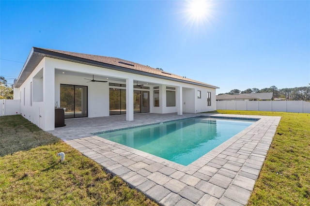 rear view of property with a fenced in pool, a yard, a patio, and ceiling fan