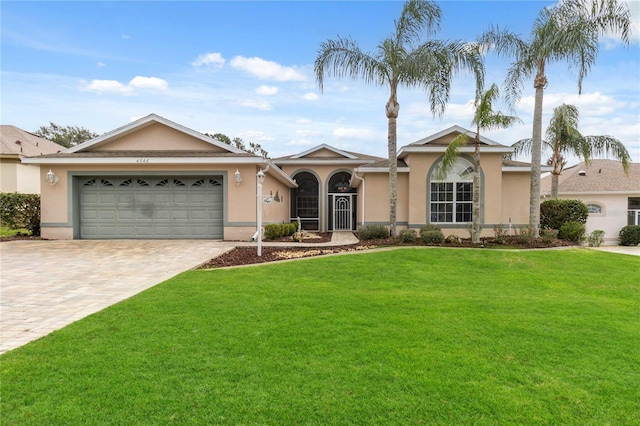 ranch-style home with a garage and a front lawn