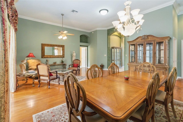 dining room with ceiling fan with notable chandelier, light hardwood / wood-style flooring, and ornamental molding