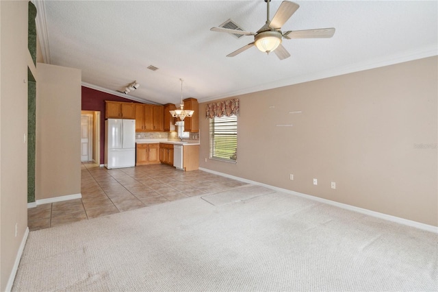 kitchen with vaulted ceiling, white appliances, light colored carpet, and decorative light fixtures