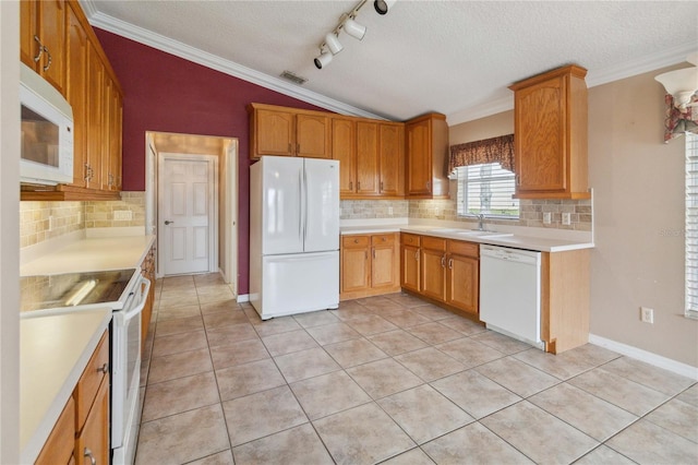 kitchen with sink, white appliances, a textured ceiling, decorative backsplash, and lofted ceiling