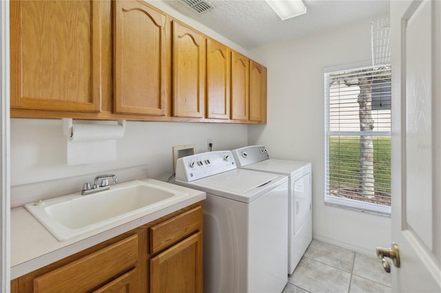 washroom featuring sink, cabinets, washer and dryer, and light tile patterned floors