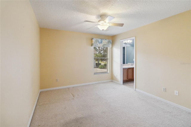 carpeted spare room featuring ceiling fan and a textured ceiling