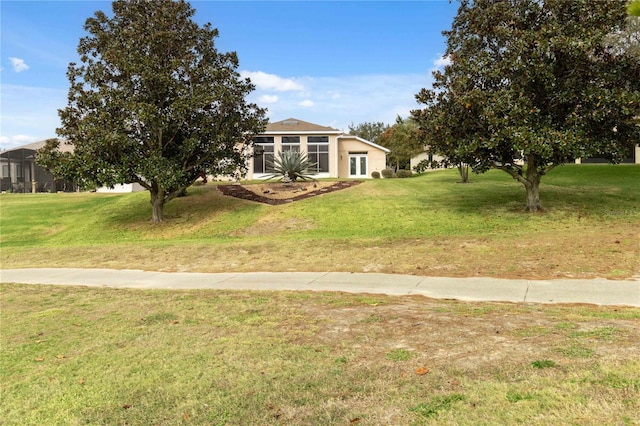 view of front of house with a front lawn and a sunroom