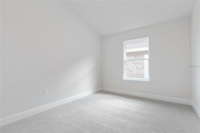 empty room featuring carpet floors and lofted ceiling