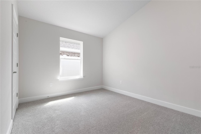 unfurnished room with carpet and lofted ceiling